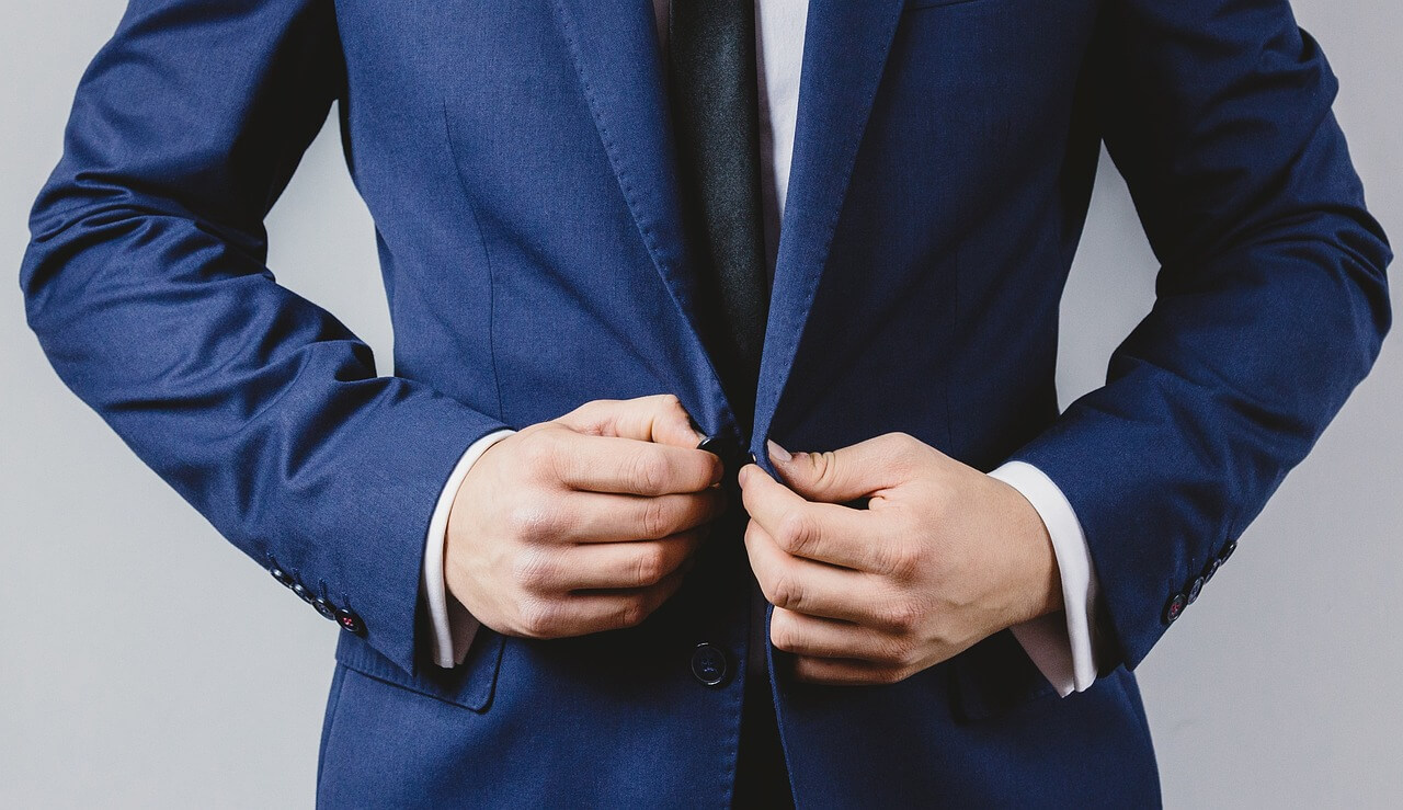 Image of internal control: A businessperson adjusting their suit.